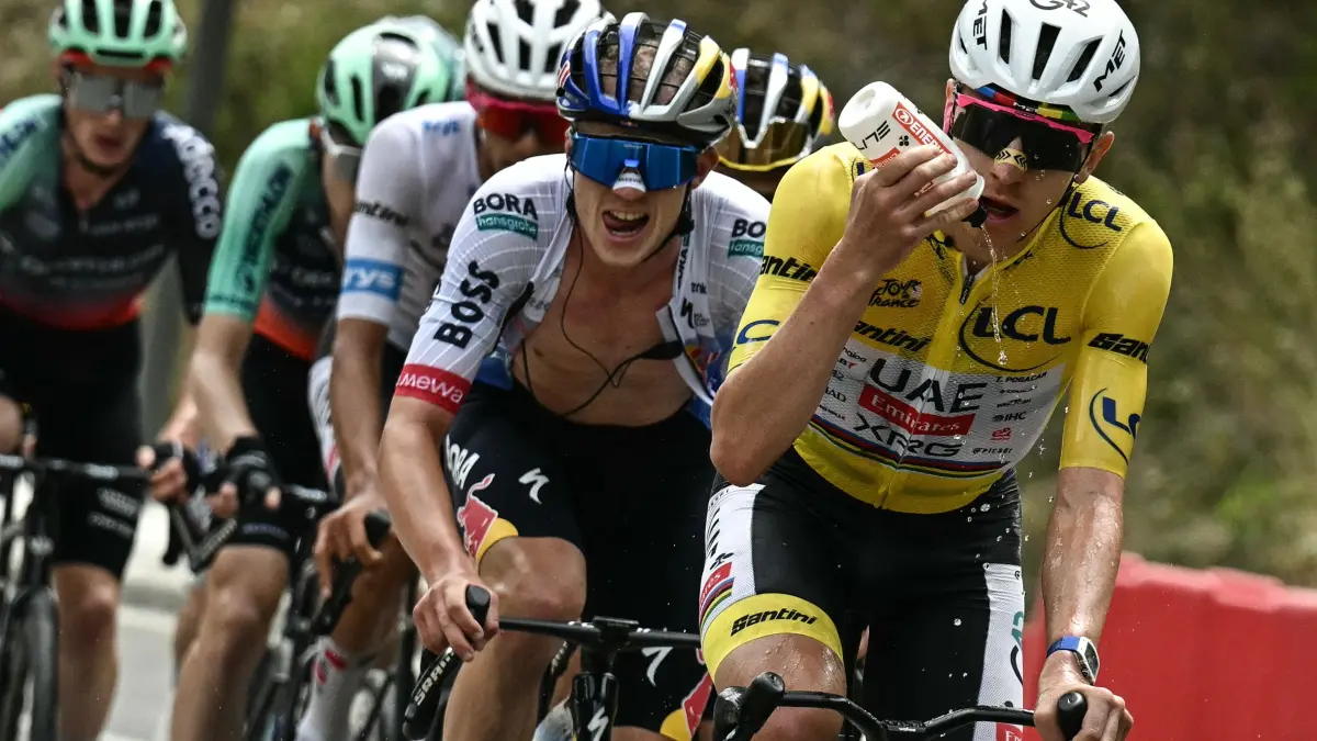 CYCLING-TDF-2026-STAGE 20: UAE Team Emirates - XRG's Slovenian rider Tadej Pogacar wearing the overall leader's yellow jersey hydrates as he cycles ahead of Red Bull - BORA - hansgrohe team's Belgian rider Remco Evenepoel in the Col du Galibier ascent during the 20th stage of the 113th edition of the Tour de France cycling race, 170,9 km between Le Bourg-d'Oisans and Alpe d'Huez in the French Alps, on July 25, 2026. (Photo by Loic VENANCE / AFP)