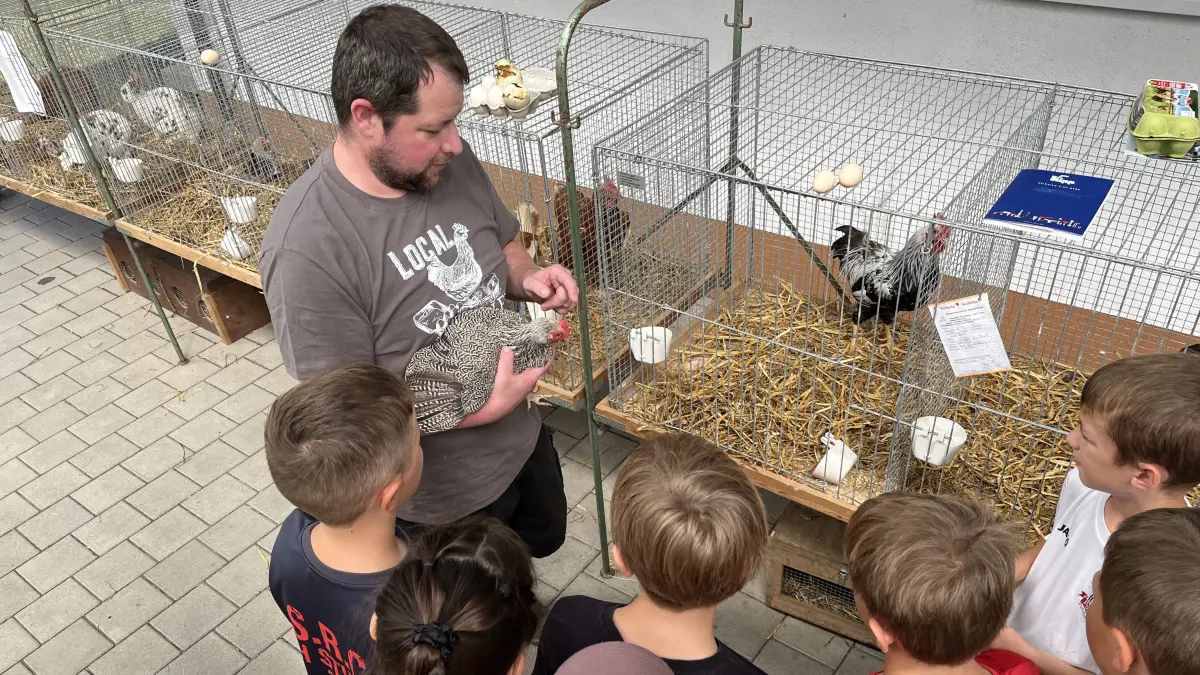 Züchter Uwe Frank erklärt den Kindern der Fischinger Grundschule die Tiere.
