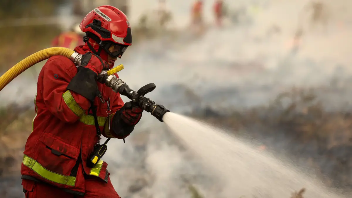 FRANCE-ENVIRONMENT-CLIMATE-WEATHER-WILDFIRE: A firefighter of Paris Fire Brigade sprays water on hotspots in Marcheprime west of Bordeaux on July 26, 2026 as a wildfire has been ravaging the forest north of the Arcachon Basin (Gironde) since July 22. The fire that has engulfed the area around the Arcachon Basin and is now threatening the outskirts of the Bordeaux metropolitan area has destroyed 42,000 hectares of “burned area,” the Gironde prefecture announced; the prefecture has evacuated a total of 220,000 people since July 22. (Photo by ROMAIN PERROCHEAU / AFP)