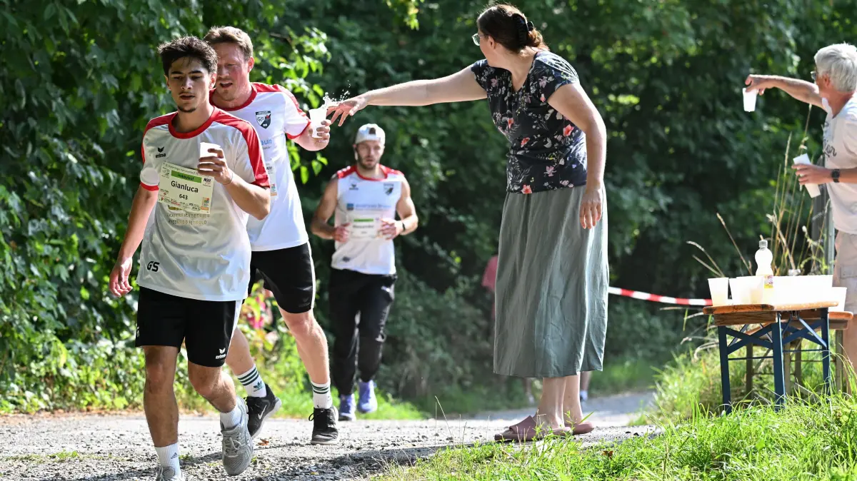 35. Kusterdinger Hornissenlauf: 35. Kusterdinger Hornissenlauf, 26.07.2026 - die Fußballer der SGM bestreiten den Hobbylauf - vorne Gianluca Sepe (SGM Kirchentellinsfurt/Kusterdingen), dahinter Wolfram Deuscher (SGM Kirchentellinsfurt/Kusterdingen), dem gerade Wasser gereicht wird
Foto: Axel Grundler
