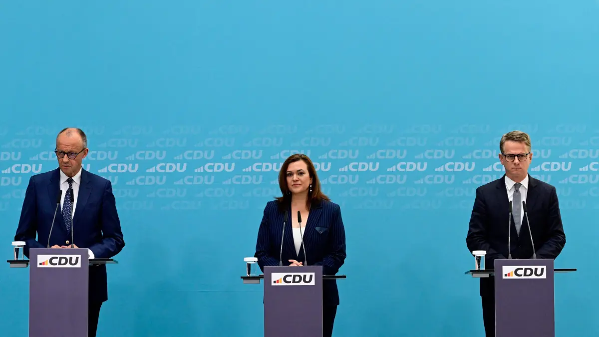GERMANY-POLITICS-GOVERNMENT-RESHUFFLE-PARTIES-CDU: (From L) German Chancellor and CDU chairman Friedrich Merz, outgoing treasurer and designated CDU Secretary General Franziska Hoppermann and outgoing Secretary General and designated German Health Minister Carsten Linnemann address a press conference to announce changes in the German government in Berlin on July 27, 2026. (Photo by John MACDOUGALL / AFP)