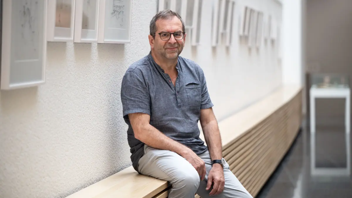 Rolf Bickelmann im Technischen Rathaus: An der Wand und in einer Vitrine sind gerade seine Zeichnungen ausgestellt.