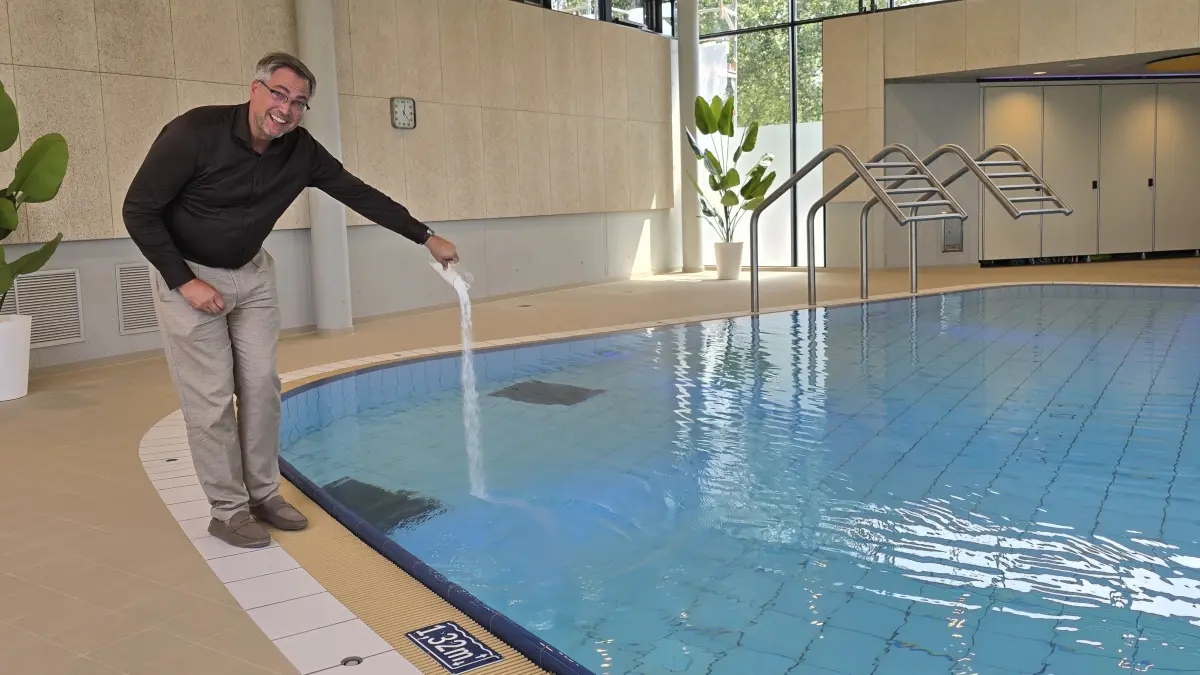 Bürgermeister Konrad Menz eröffnet mit einer Prise Mineralien das neue Solebecken im Erweiterungsbau des Bad Blau in Blaustein.