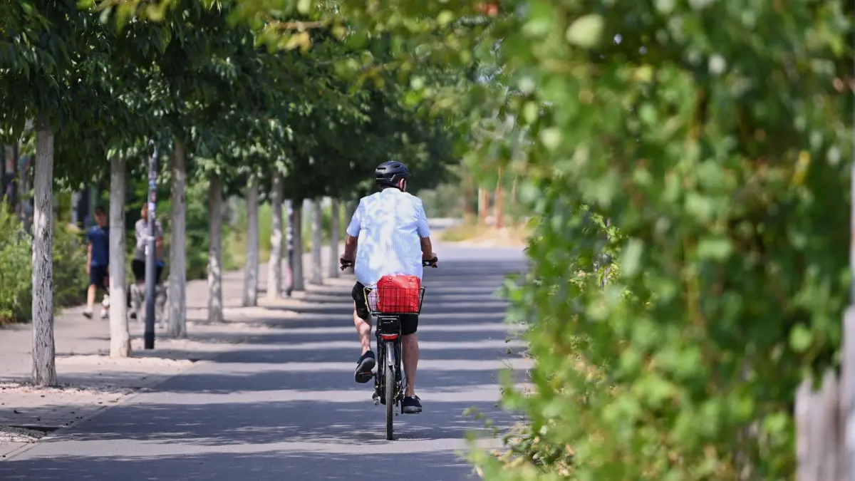 Wetter in Offenbach am Main: 31.07.2026, Hessen, Offenbach am Main: Ein Mann fährt am Offenbacher Mainufer mit dem Fahrrad in Richtung Frankfurt. Die Temperaturen steigen heute in Hessen nach Angaben des Deutschen Wetterdienstes gebietsweise auf 30 bis 34 Grad an. Foto: Jennifer Brückner/dpa +++ dpa-Bildfunk +++