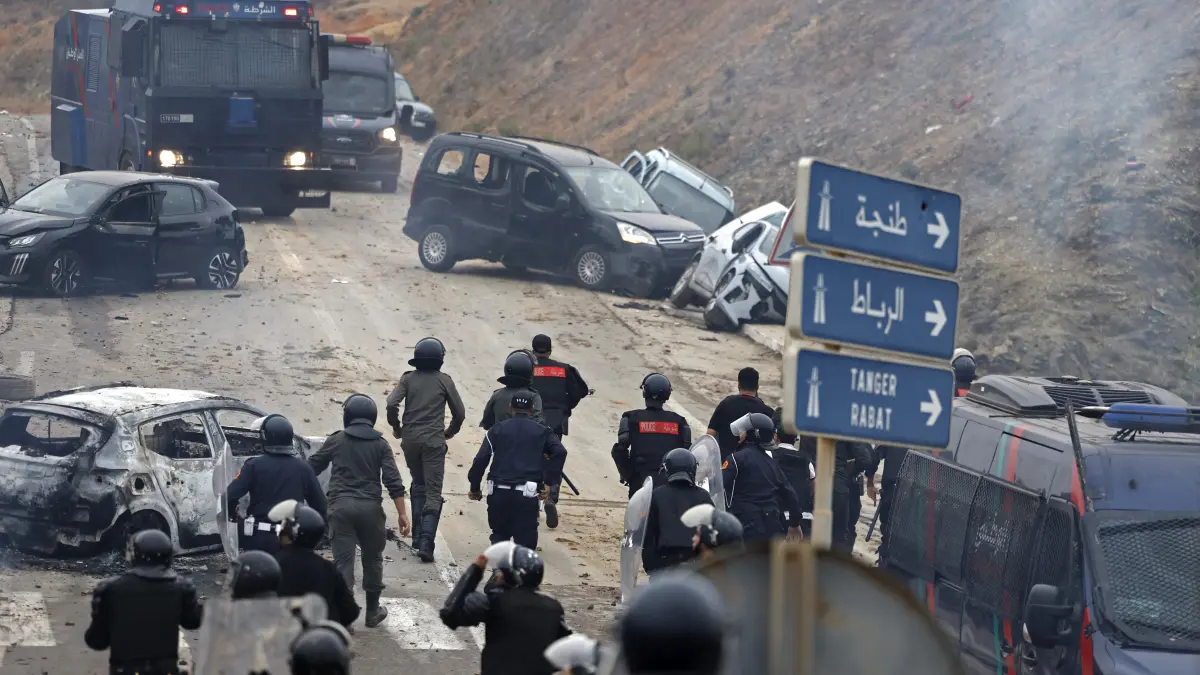 MOROCCO-SPAIN-MIGRATION: Members of Moroccan security forces gather at the site of clashes near Fnideq, on the Morocco-Spain border, on July 31, 2026. Thousands of migrants crossed overnight from Morocco into Spain's north Africa's Ceuta enclave, a police source said on July 31, adding that it was impossible to estimate how many people in total. A total of 18 people died while attempting to reach the Spanish enclave, the source said. (Photo by Abdel Majid BZIOUAT / AFP)