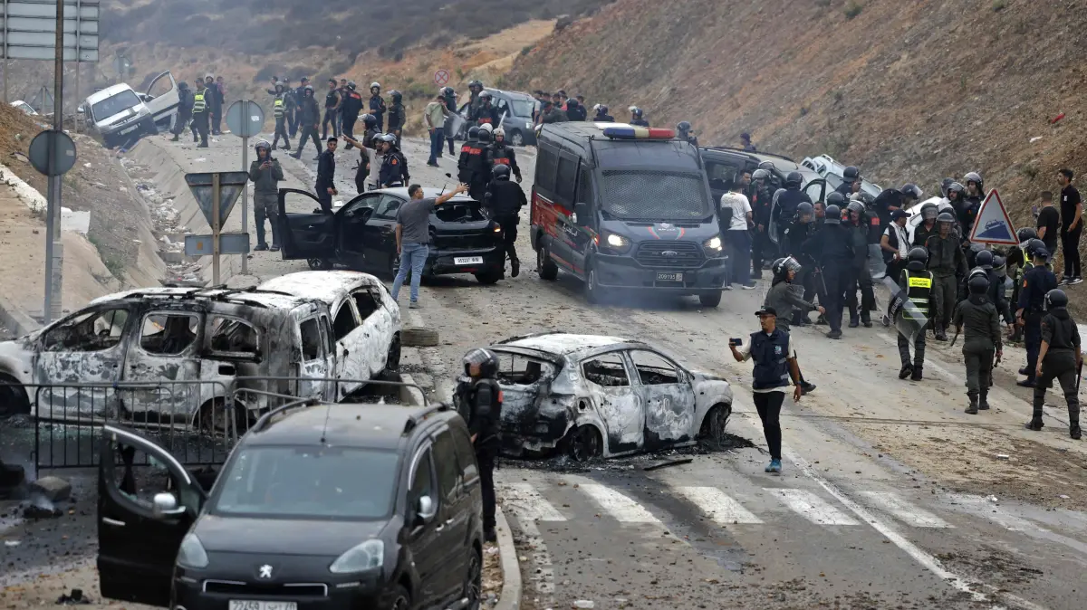 MOROCCO-SPAIN-MIGRATION: Members of Moroccan security forces gather at the site of clashes near Fnideq, on the Morocco-Spain border, on July 31, 2026. Thousands of migrants crossed overnight from Morocco into Spain's north Africa's Ceuta enclave, a police source said on July 31, adding that it was impossible to estimate how many people in total. A total of 18 people died while attempting to reach the Spanish enclave, the source said. (Photo by Abdel Majid BZIOUAT / AFP)