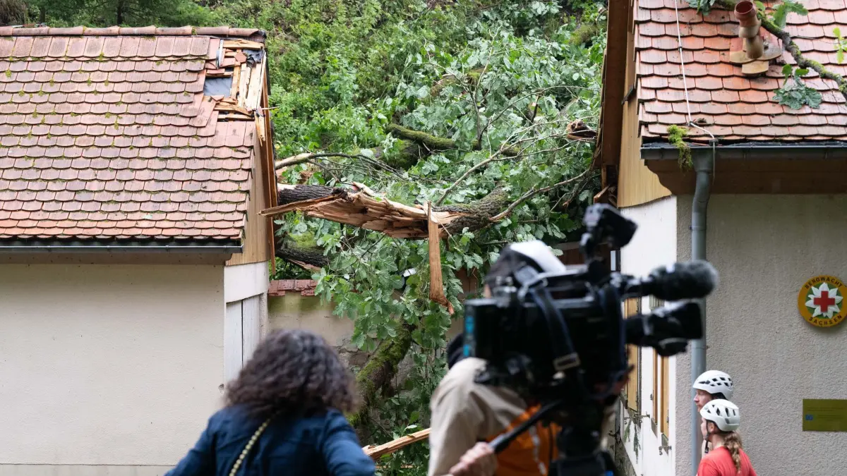Sturmschäden Sächsische Schweiz: 01.08.2026, Sachsen, Rathen: Sturmschäden an einem Gebäude der Bergwacht Sachsen im Amselgrund im Nationalpark Sächsische Schweiz. Nach dem schweren Unwetter mit einem Toten und drei Schwerverletzten ist der Nationalpark für Besucher gesperrt. Foto: Sebastian Kahnert/dpa +++ dpa-Bildfunk +++