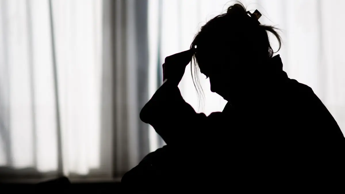 Die Zahl der Krankheitstage wegen psychischer Leiden wächst: ARCHIV - 19.02.2025, Niedersachsen, Hannover: Die Silhouette einer Frau zeichnet sich vor einer hellen Fensterfront ab (gestellte Szene). (zu dpa: «KKH: Belastungsreaktionen und Anpassungsstörungen nehmen zu») Foto: Julian Stratenschulte/dpa +++ dpa-Bildfunk +++
