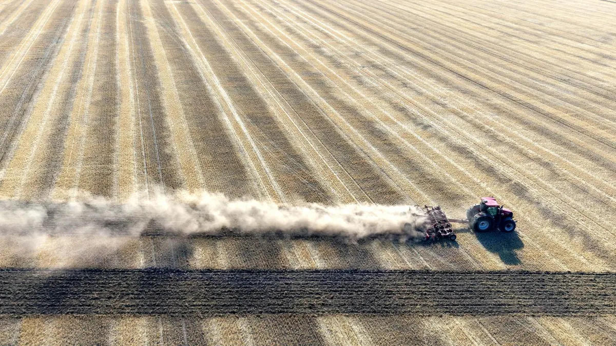 Trockenheit in Österreich: 03.08.2026, Österreich, Leopoldsdorf im Marchfelde: Ein Traktor beim Auflockern des Bodens nach der Getreideernte in Niederösterreich. Die anhaltende Trockenheit, Hitze und Dürre setzen der Landwirtschaft in Österreich weiterhin zu. Die Böden sind hart und zu trocken. (Luftaufnahme) Foto: Harald Schneider/APA/dpa +++ dpa-Bildfunk +++