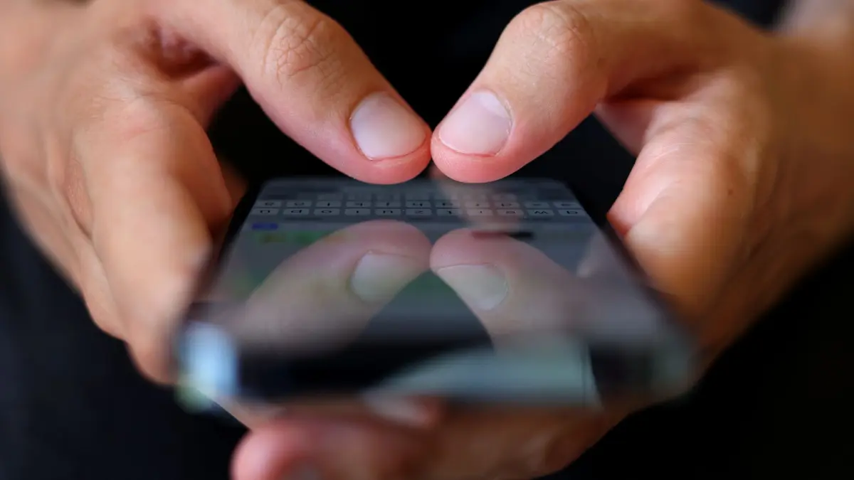 Handy: ILLUSTRATION - 06.07.2022, Bayern, Augsburg: Person hält Handy in der Hand. (zu dpa: «Betrüger leiten Gehalt auf fremdes Konto um») Foto: Karl-Josef Hildenbrand/dpa +++ dpa-Bildfunk +++