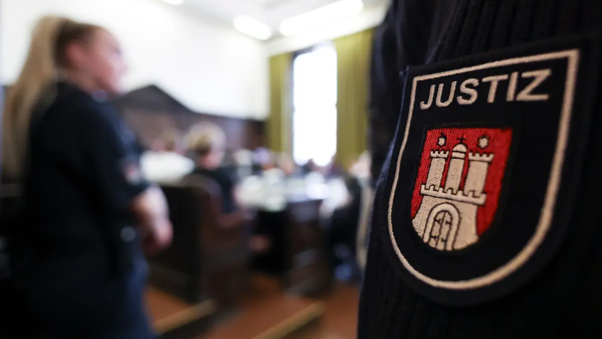 Urteil Prozess gegen rechtsextreme Terrorgruppe: 05.08.2026, Hamburg: Die Angeklagten sitzen im Sitzungssaal im Strafjustizgebäude zu Beginn eines weiteren Prozesstags im Prozess gegen die rechtsextreme Terrorgruppe «Letzte Verteidigungswelle». In dem Prozess gegen sieben mutmaßliche Mitglieder und einen Unterstützer der rechtsextremen Terrorgruppe "Letzte Verteidigungswelle" wird vor dem Hanseatischen Oberlandesgericht am Mittwoch das Urteil gesprochen. Foto: Christian Charisius/dpa +++ dpa-Bildfunk +++