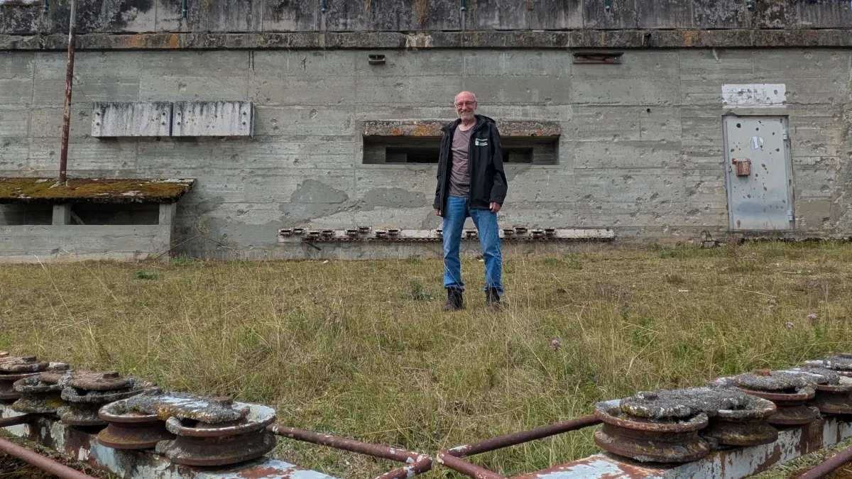 Naturschutzwart Erhard Holzschuh steht vor einem Steuerbunker, von dem aus Klappziele per Seilzug aufgestellt wurden. Trüp-Touren der Stadt Münsingen bekommen sogar einen Blick hinein.