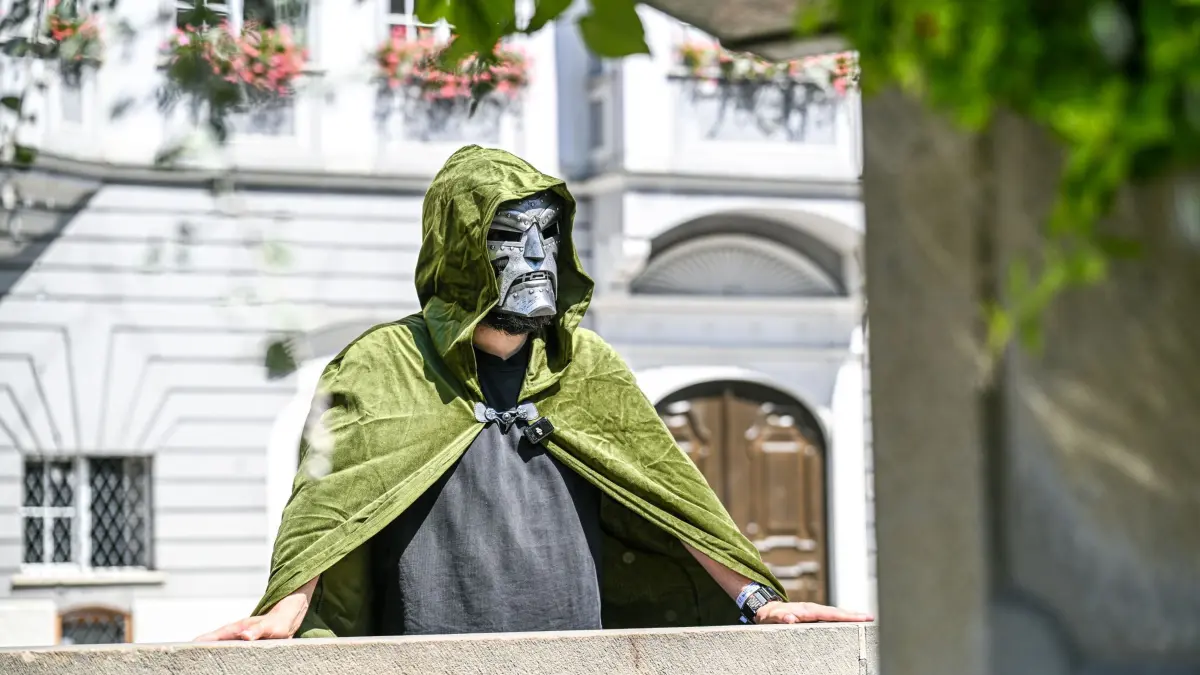 Memmingen lädt Marvel mit Humor-Video zum Avengers-Start ein: 05.08.2026, Bayern, Memmingen: Oberbürgermeister Jan Rothenbacher (SPD) steht im Kostüm von Doctor Doom auf dem Marktplatz vor dem Memminger Rathaus. Mit einem humorvollen Video will die Stadt Memmingen die Premiere des neuen «Avengers»-Film nach Bayerisch-Schwaben holen. Foto: Jason Tschepljakow/dpa +++ dpa-Bildfunk +++