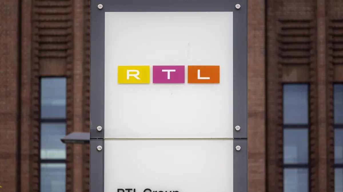 Ein Firmenschild von RTL Deutschland und RTL Group steht vor dem Sendezentrum des privaten Fernsehsenders in Köln. Der Fernsehkonzern korrigierte seine Jahresprognose nach unten, wie die Fernsehgruppe am Dienstag in Luxemburg mitteilte. +++ dpa-Bildfunk +++