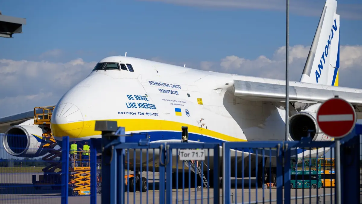 Nach Drohnenvorfall am Flughafen Leipzig/Halle: 06.08.2026, Sachsen, Schkeuditz: Eine ukrainische Antonov parkt am Flughafen Leipzig/Halle hinter einem Zaun auf dem Flughafengelände. Nach dem Drohnenvorfall in der Nacht zum Mittwoch laufen die Ermittlungen. Die für einen Angriff ausgerüstete Drohne war nach Angaben aus Sicherheitskreisen nahe einer ukrainischen Transportmaschine sichergestellt worden. Die Sicherheitsbehörden sind alarmiert. Foto: Hendrik Schmidt/dpa +++ dpa-Bildfunk +++