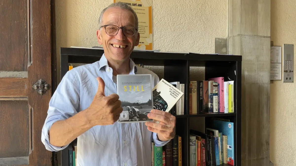Der ehemalige Buchhändler Samy Wiltschek inspiziert das Buchtauschregal vor dem Café Jam am Münsterplatz und ist dort auch selbst fündig geworden. Er findet das Angebot super und rät jeder Leseratte zu einem Besuch.