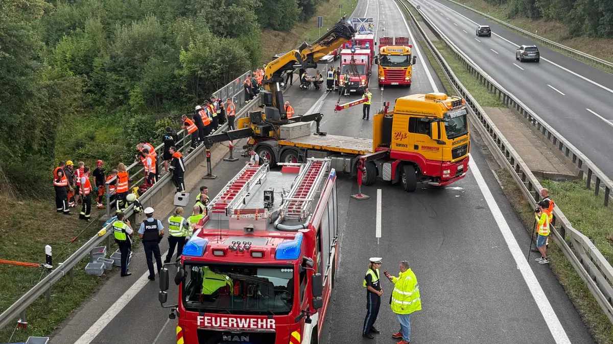 Unfall an der A3 bei Regensburg: 06.08.2026, Bayern, Regensburg: Einsatzkräfte der Feuerwehr arbeiten nach einem Unfall auf der Autobahn 3 (A3) bei Regensburg. Drei Menschen sind bei einem schweren Unfall auf der Autobahn 3 in der Oberpfalz ums Leben gekommen, als ihr Wagen von der Fahrbahn abkam und auf eine Bahnstrecke geriet. Foto: Armin Weigel/dpa +++ dpa-Bildfunk +++