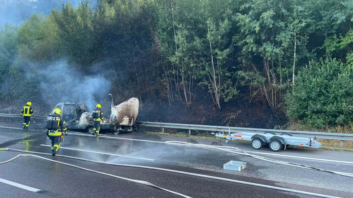 Brennendes Wohnmobil bei: HANDOUT - 05.08.2026, Hessen, Niedernhausen: Die vom Polizeipräsidium Westhessen zur Verfügung gestellte Aufnahme zeigt Einsatzkräfte der Feuerwehr beim Löschen eines brennenden Wohnmobils. Ein brennendes Wohnmobil hat ein Waldstück neben der Autobahn in Brand gesetzt. Das Fahrzeug sei auf der A3 bei Niedernhausen (Rheingau-Taunus-Kreis) komplett ausgebrannt, wie die Polizei mitteilte. Auch zwei Propangasflaschen seien durch das Feuer am Mittwochabend explodiert. Foto: Polizeipräsidium Westhessen/dpa +++ dpa-Bildfunk +++