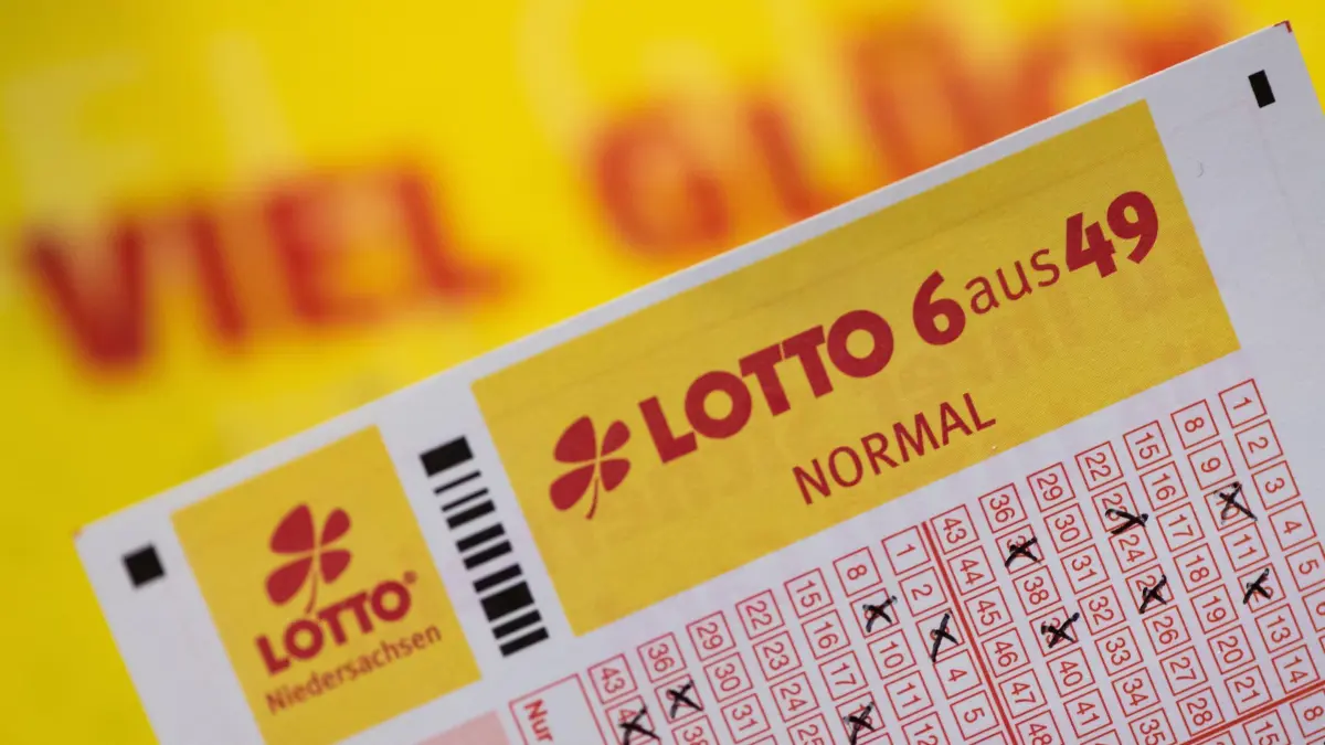 Lotto: SYMBOLBILD - 22.01.2020, Niedersachsen, Göttingen: Ein Lottoschein mit der Aufschrift «Lotto 6 aus 49» ist vor einem Schriftzug «Viel Glück» zu sehen. (zu dpa: «Lotto: Warum bei 50 Millionen Euro Schluss ist») Foto: Swen Pförtner/dpa +++ dpa-Bildfunk +++