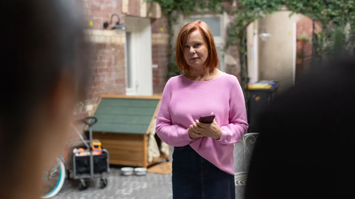 Irene (Petra Blossey) trommelt die Hausbewohner zusammen, um ihren Zusammenhalt zu beschwören.