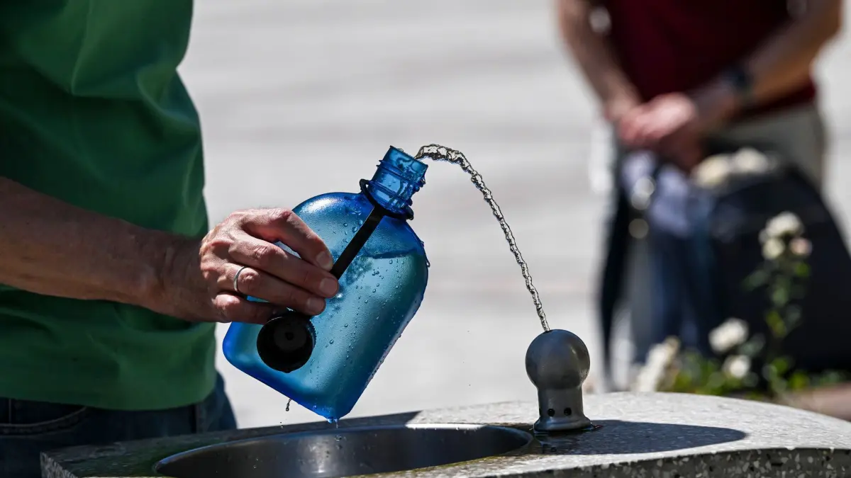 Hitze in Berlin: ARCHIV - 23.06.2026, Berlin: Ein Mann nutzt auf dem Gendarmenmarkt einen Wasserspender, um seine Trinkflasche aufzufüllen. (zu dpa: «Was tut die Bundesregierung gegen die Hitzetoten?») Foto: Jens Kalaene/dpa +++ dpa-Bildfunk +++