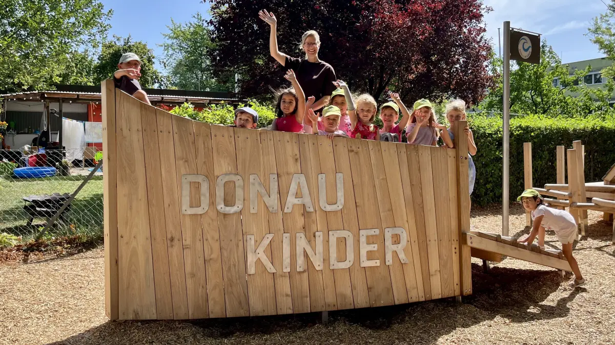 Schöner Start in den 24-Stunden-Tag: Die Neu-Ulmer Oberbürgermeisterin Katrin Albsteiger umringt von Mädchen und Buben in der Kita Donaukinder.