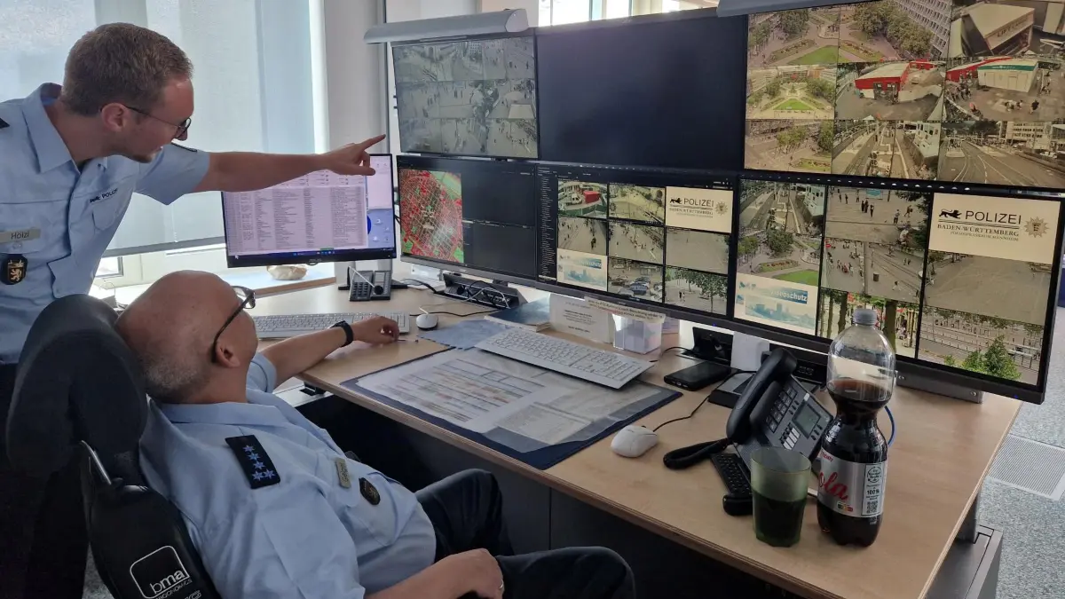 Polizei-Projektleiter Videoschutz Philipp Hölzl (l.) und Stephan Geiger an einem der Videoüberwachungs-Arbeitsplätze im Mannheimer Polizeipräsidium.