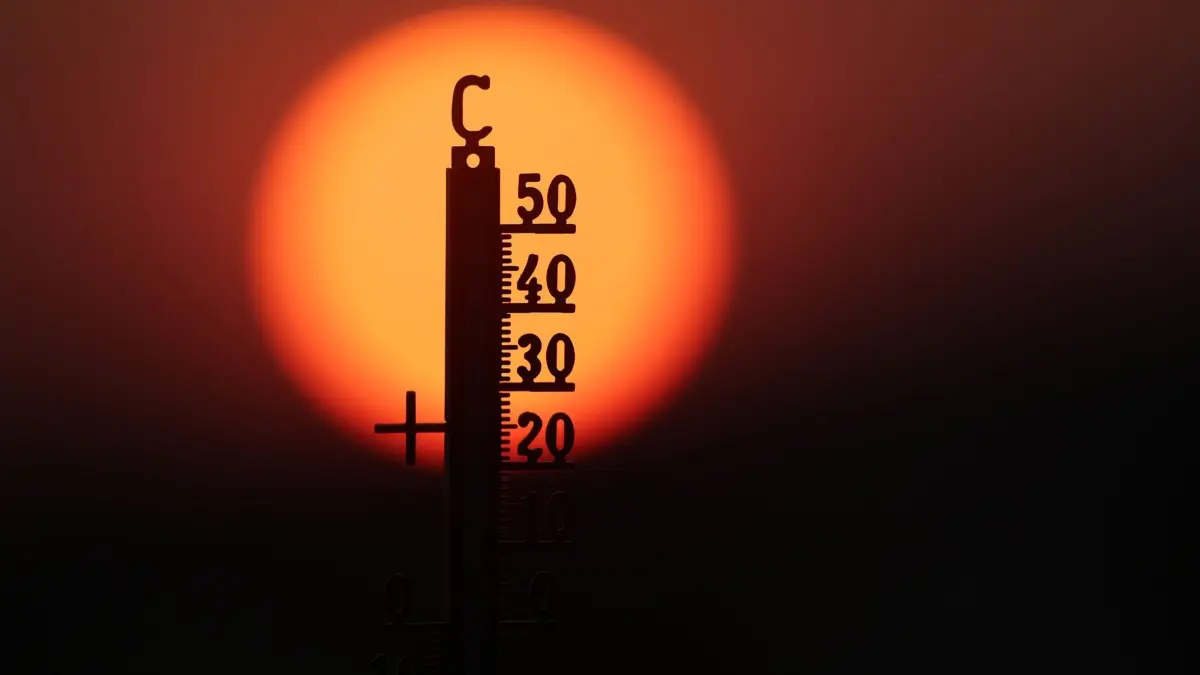 Hitze in Deutschland: ARCHIV - 21.06.2026, Baden-Württemberg, Unlingen: Hinter einem Thermometer geht am Morgen die Sonne auf. (zu dpa: «Juni und Juli waren in Westeuropa so warm wie noch nie») Foto: Thomas Warnack/dpa +++ dpa-Bildfunk +++