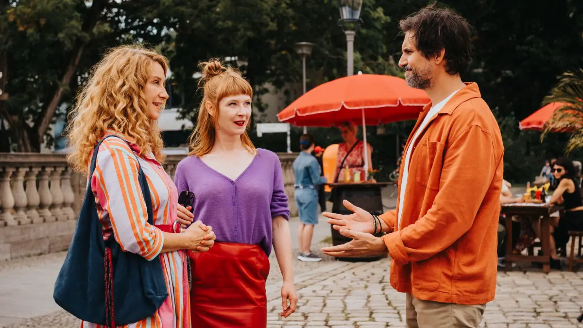 Caro Sander (Chiara Schoras, l.) muss Anya Urbanski (Sarah Bauerett) mit Marc Ahmadi (Tom Beck) verkuppeln, obwohl sie den Musiklehrer selbst attraktiv findet.