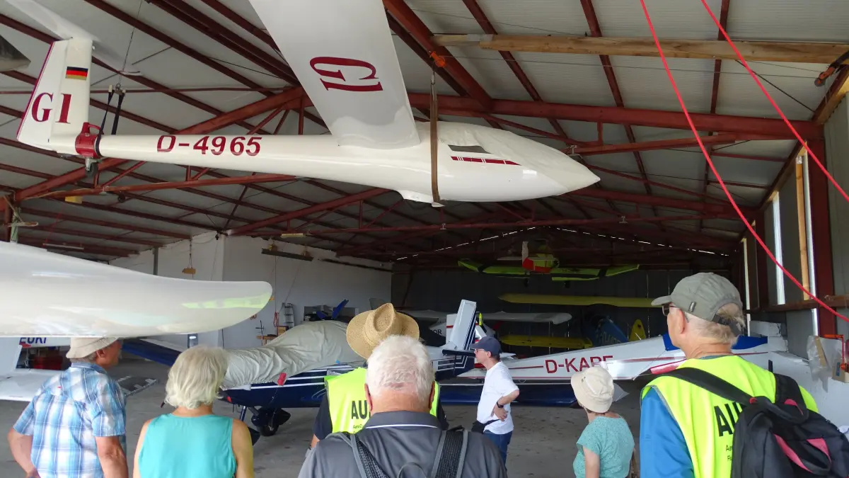 Im großen Hangar des AeroClub Göppingen-Salach e.V. befinden sich Segelflugzeuge und Motorflugzeuge. Die Gäste der Führung betrachteten mit großem Interesse die Maschinen, am Boden und unter der Decke hängend.