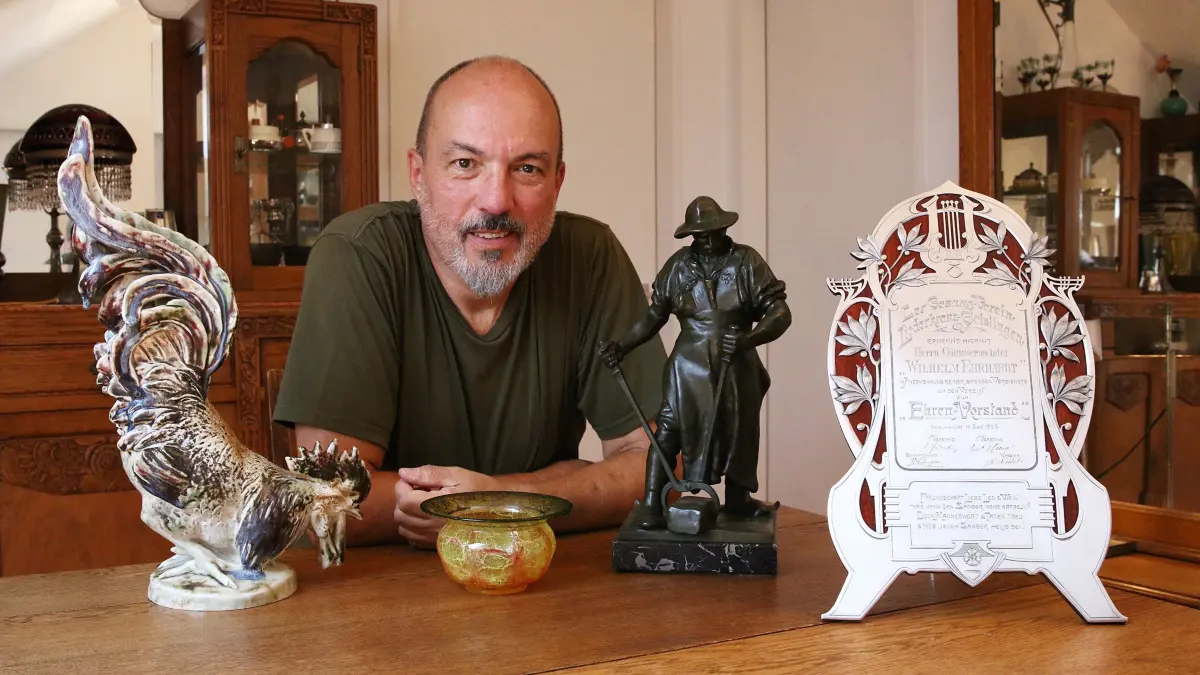 Sommerferienserie WMF-Exponate von Werner Abele aus Steinenkirch Teil VII Besonderes und Kurioses. Werner Abele inmitten außergewöhnlicher WMF-Besonderheiten. Ein Keramik-Gockel, der ebenfalls nirgends in einem der Kataloge von Werner Abele auftaucht und zu dem er deshalb nicht viel sagen kann. Es ist eins der kuriosen Ausstellungsstücke der WMF.
