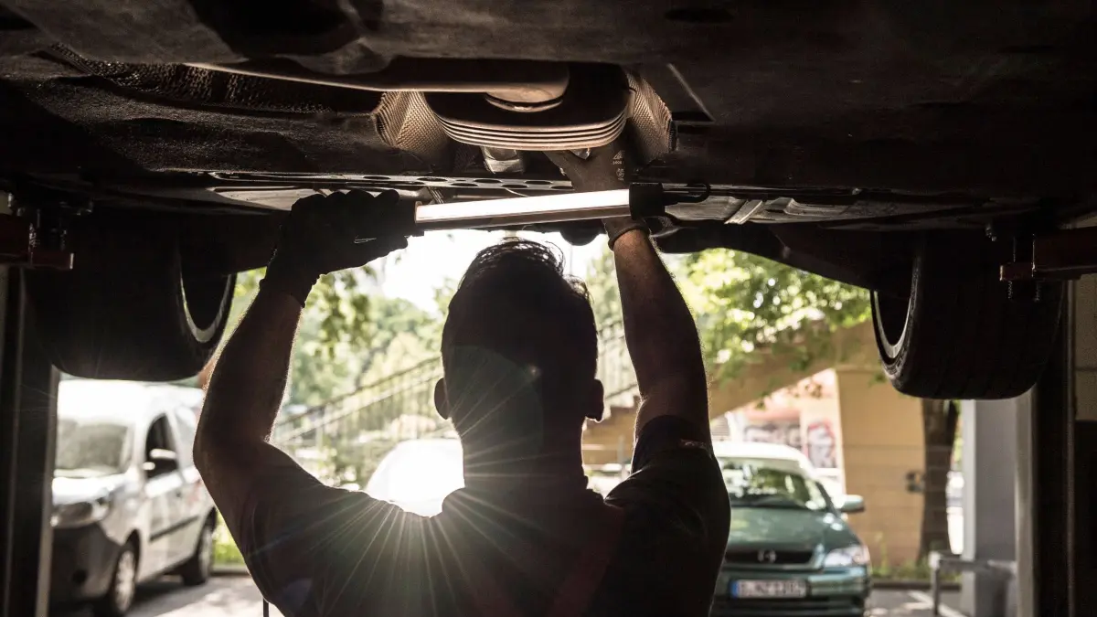 Ein Mechatroniker arbeitet in einer Auto-Werkstatt: ILLUSTRATION - Mitunter fordern Werkstätten einen Vorschuss, ehe die Reparatur beginnt – fließt kein Geld, wird auch nicht geschraubt. (zu dpa: «Unfall: Muss die Versicherung monatelang Mietwagen zahlen?») Foto: Robert Günther/dpa-tmn - Honorarfrei nur für Bezieher des dpa-Themendienstes +++ dpa-Themendienst +++