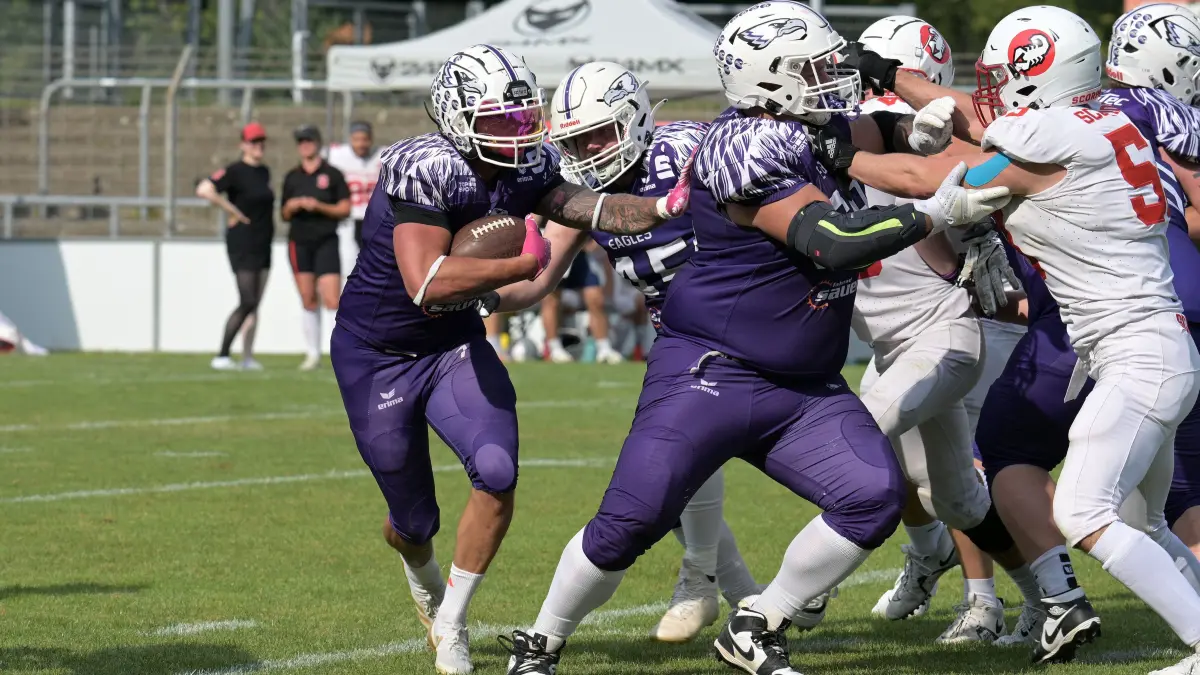 American Football RL | SSV Reutlingen 05 Eagles vs. Stuttgart Scorpions: American Football | SSV Reutlingen 05 Eagles (lila) vs. Stuttgart Scorpions (weiss) // 2026-08-15 // Foto: JoBaur // #7 Pascal Lauber (SSV Reutlingen Eagles), mit Ball / #45 Felix Gerdes (SSV Reutlingen Eagles), mitte/hinten / #68 Benjamin Petrova (SSV Reutlingen Eagles) haelt #53 David Forti (Stuttgart Scorpions), re