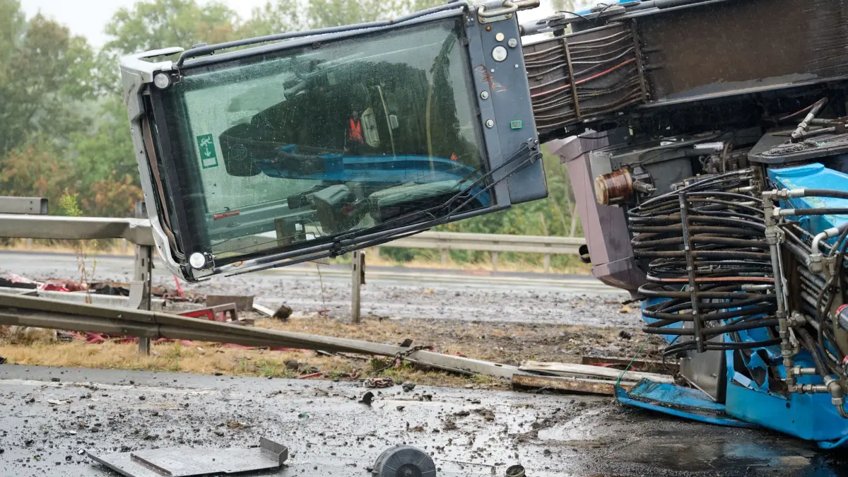 Schwertransporter mit Baukran umgekippt: 18.08.2026, Nordrhein-Westfalen, Kamen: Das Führerhaus eines umgekippten Baukrans, der nach einem Unfall quer über dem Mittelstreifen der Autobahn A2 liegt, nachdem er bei dem Unfall von einem Schwerlasttransporter gerutscht war. Die Autobahn in Richtung Hannover und Oberhausen ist dadurch blockiert. Foto: Bernd Thissen/dpa +++ dpa-Bildfunk +++