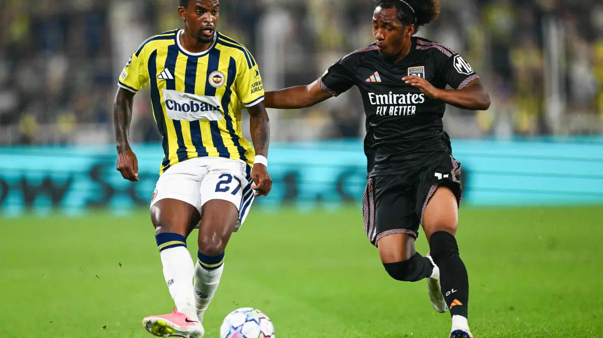 FBL-EUR-C1-QUALIFYING-FENERBAHCE-LYON: Fenerbahce's Portuguese defender #27 Nelson Semedo (L) fights for the ball with Lyon's Belgian forward #11 Malick Fofana during the UEFA Champions League qualifying playoff - first leg football match between Fenerbahce SK and Olympique Lyonnais (OL) at the Sukru Saracoglu Stadium in Istanbul on August 18, 2026. (Photo by YASIN AKGUL / AFP)