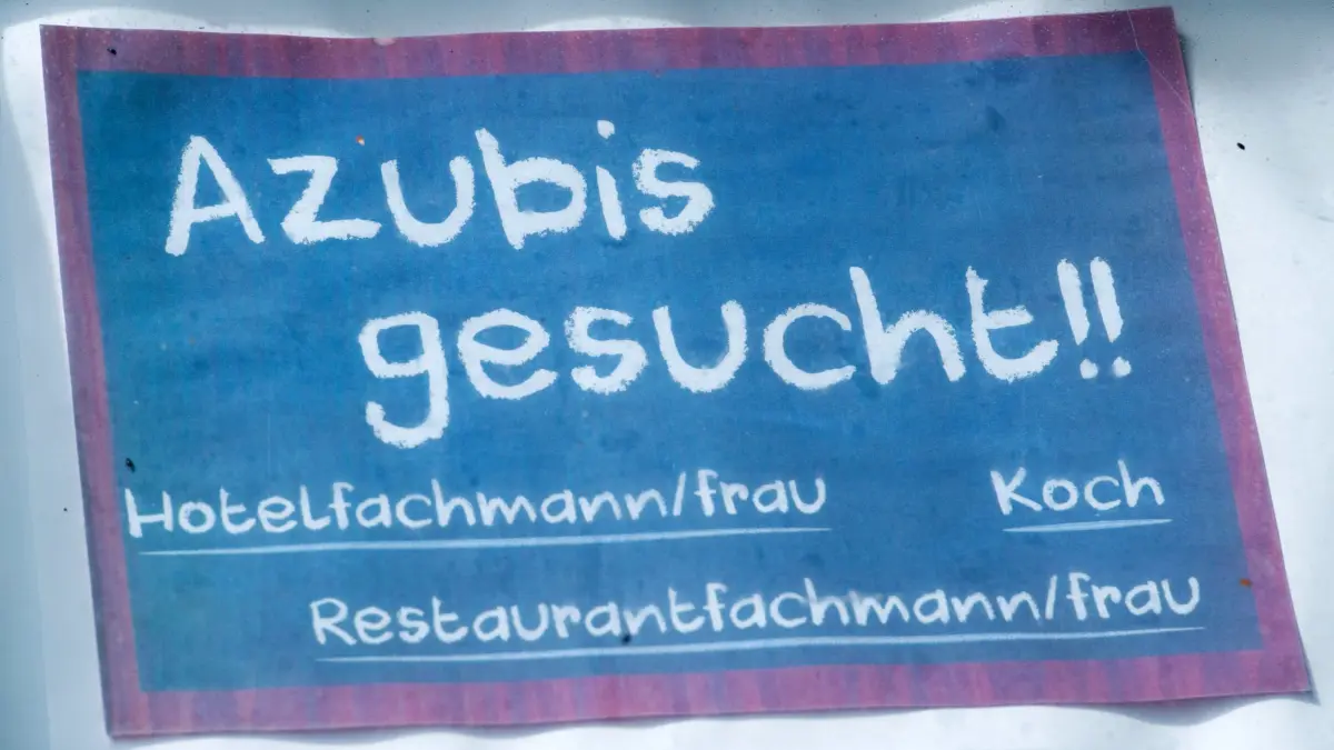 Auszubildende: ARCHIV - 27.06.2016, Mecklenburg-Vorpommern, Binz: Mit einem Schild werden Auszubildende für die Arbeit in der Gastronomie gesucht. (Archivbild) (zu dpa: «DGB-Studie: Jeder zweite Azubi fühlt psychische Belastung») Foto: Stefan Sauer/dpa +++ dpa-Bildfunk +++
