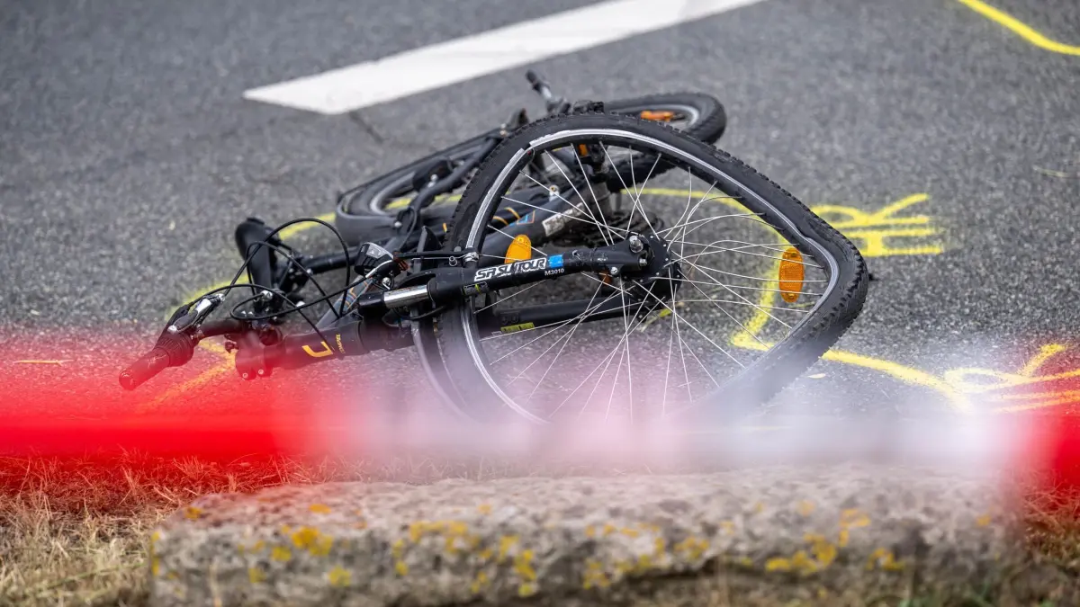 Kind wird in Bremen von Auto erfasst und schwer verletzt: 20.08.2026, Bremen: Ein beschädigtes Fahrrad steht an einer Unfallstelle, nachdem ein Kind bei einem Unfall schwer verletzt wurde. Nach ersten Erkenntnissen der Polizei war das Kind auf einem Fahrrad unterwegs und wurde von einem Auto erfasst. Foto: Sina Schuldt/dpa +++ dpa-Bildfunk +++