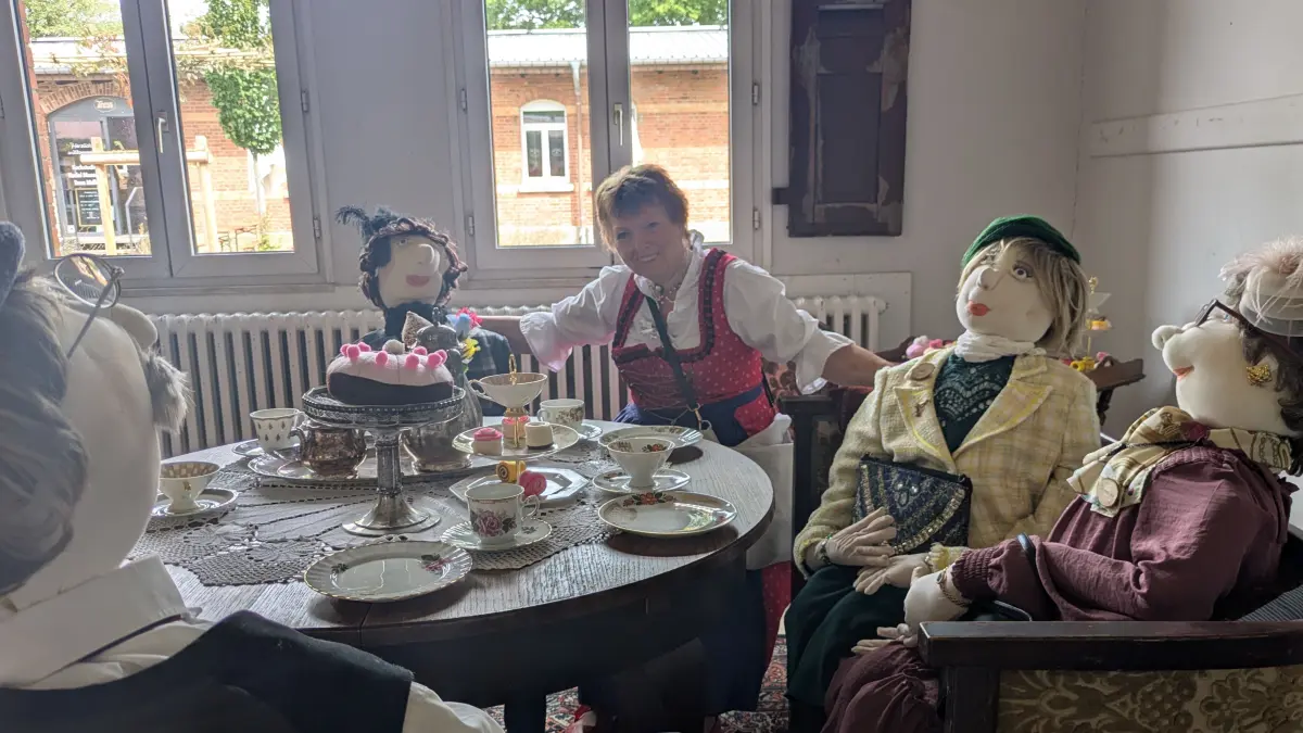 Anneliese Schnitzler sitzt mit ihrer Puppenfamilie beim Kaffee. Der Bankdirektor hat zu Filz-Kuchen und süßen Filzstückchen geladen.