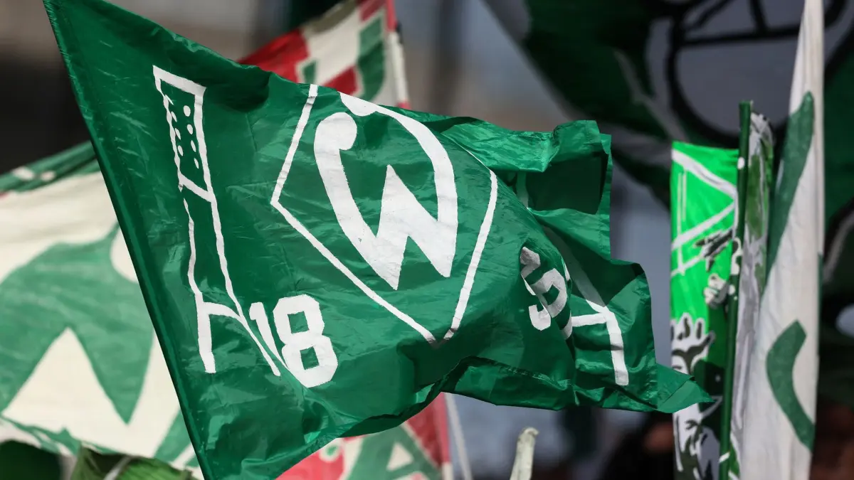 Lüneburger SK - Werder Bremen: 22.08.2026, Hamburg: Fußball, Männer: DFB-Pokal, Lüneburger SK - Werder Bremen, 1. Runde, im Millerntor-Stadion: Fans von Werder Bremen schwenken Fahnen vor dem Spiel. Foto: Selim Sudheimer/dpa - WICHTIGER HINWEIS: Gemäß den Vorgaben der Bundesliga bzw. des DFB Deutscher Fußball-Bund ist es untersagt, in dem Stadion und/oder vom Spiel angefertigte Fotoaufnahmen in Form von Sequenzbildern und/oder videoähnlichen Fotostrecken zu verwerten bzw. verwerten zu lassen. +++ dpa-Bildfunk +++