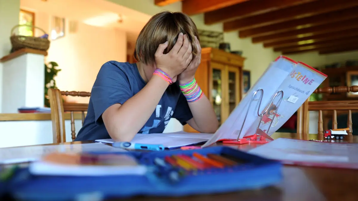 Junge hält sich bei den Hausaufgaben den Kopf: ILLUSTRATION - 02.05.2011, Nordrhein-Westfalen, Arnsberg: Kinder mit ADHS haben unter anderem häufig Probleme mit der Konzentration, etwa auf Schulstoff. Diagnose und Therapie gehört in die Hände von Fachpersonen mit entsprechender Qualifikation. (zu dpa: «Deutlich mehr ADHS-Diagnosen bei Kindern und Jugendlichen») Foto: Julian Stratenschulte/dpa/dpa-tmn +++ dpa-Bildfunk +++