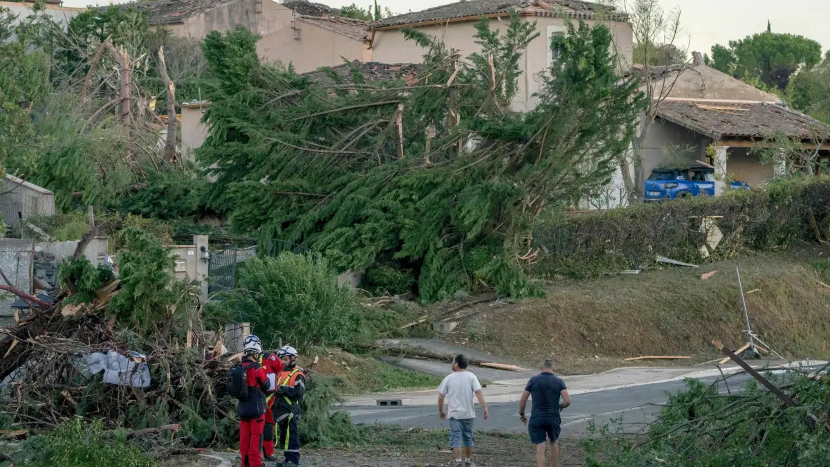 Unwetter in Frankreich - Tornado: 24.08.2026, Frankreich, Pompas: Feuerwehrleute stehen nach einem Tornado an umgestürzten Bäumen und beschädigten Häusern. Foto: Idriss Bigou-Gilles/AFP/dpa +++ dpa-Bildfunk +++