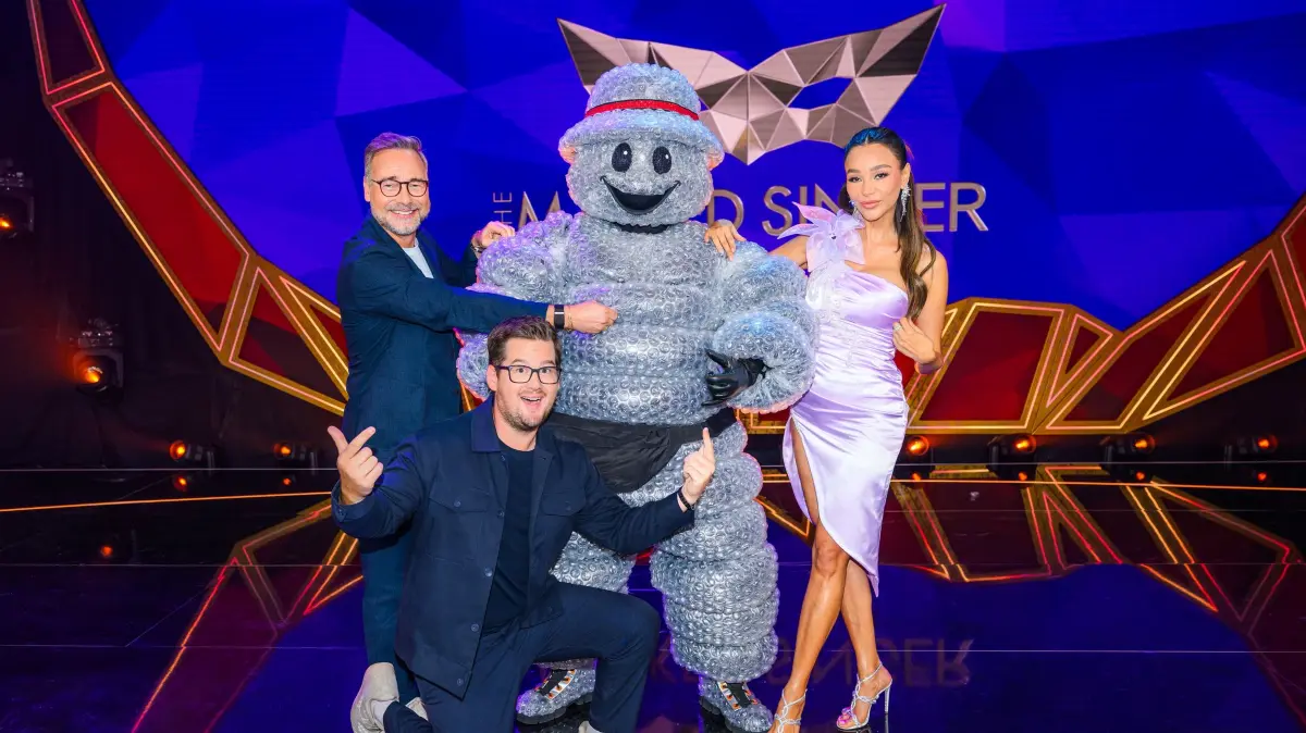 Chris Tall (M.) und Verona Pooth (r.) sind das Rateteam von „The Masked Singer“ 2026.