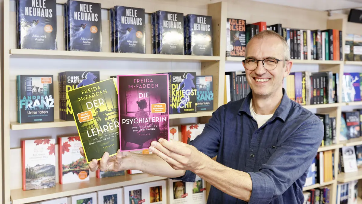 Was sind die aktuellen Lesetrends? Die Thriller von McFadden werden rauf und runter gelesen, sagt Thomas Ziegler von der gleichnamigen Buchhandlung in Geislingen auf die Frage nach den aktuellen Lesetrends. Im Bild: Thoms Ziegler in der Hand zwei Thriller von Freida Mc Fadden. Links: Der Lehrer, rechts: Die Psychiaterin.