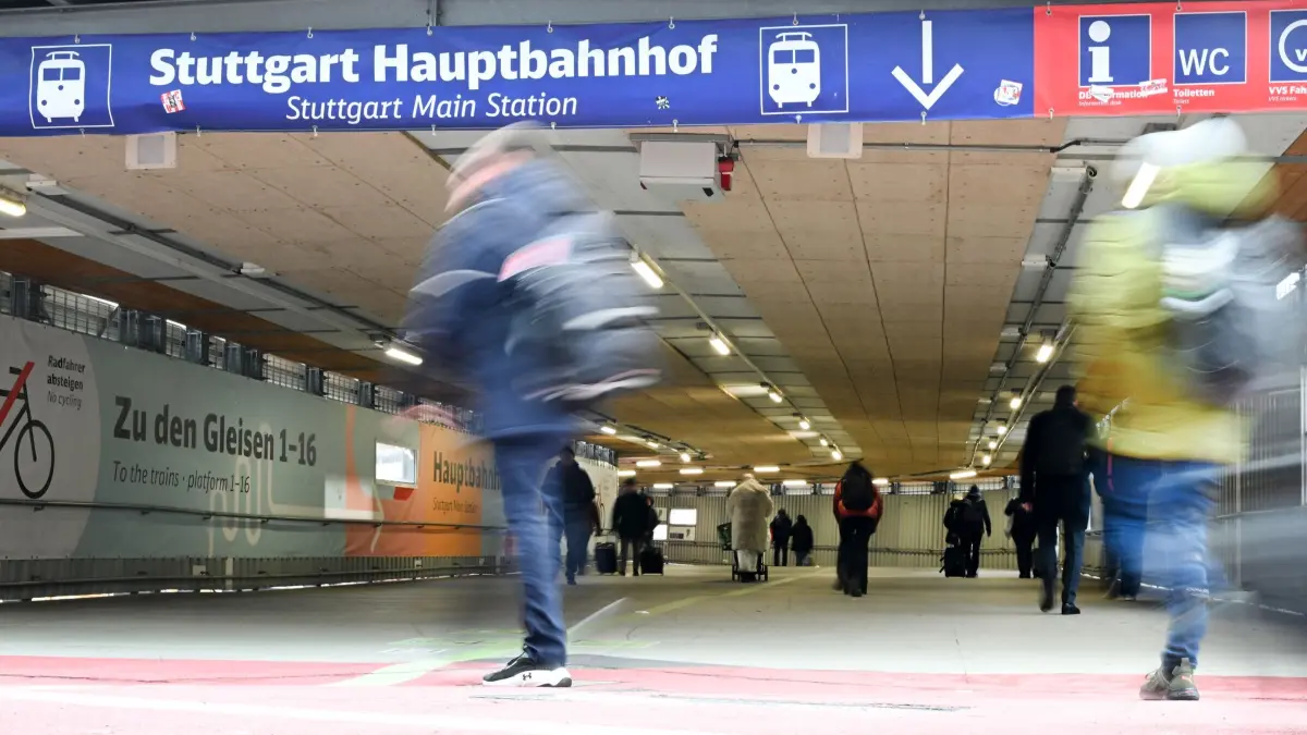 Stuttgarter Bahnhofs-Tunnel: PRODUKTION - 28.11.2025, Baden-Württemberg, Stuttgart: Personen laufen zu den Gleisen am Stuttgarter Hauptbahnhof durch einen provisorischen Durchgang (Wischeffekt durch Bewegung bei Langlzeitbelichtung). Bis Ende 2027 bleibt der Spaziergang zumindest für Reisende noch Pflichtprogramm. (zu dpa: «Frust als Feature: Ein Spiel über den S21-Fußgänger-Tunnel») Foto: Bernd Weißbrod/dpa +++ dpa-Bildfunk +++