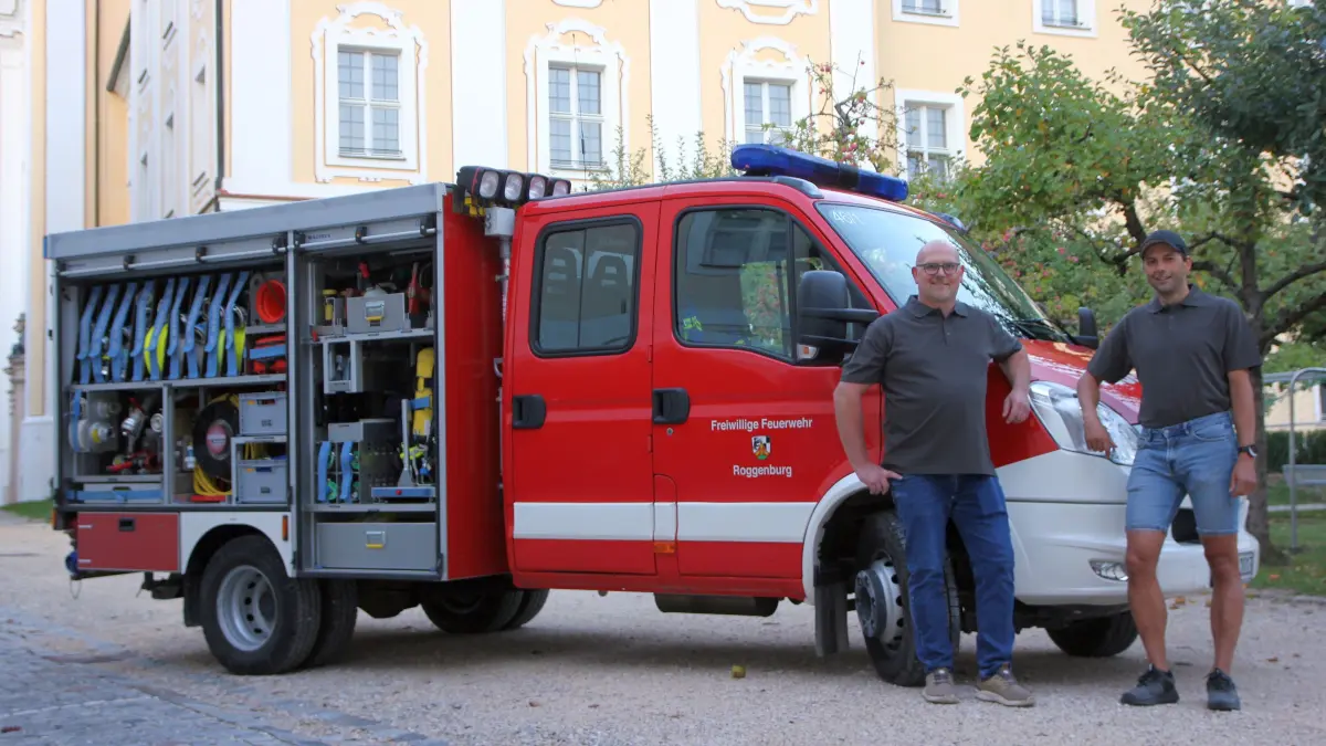 Michael Blum (links) und Marcell Mareis von der Freiwilligen Feuerwehr Roggenburg mit dem Tragkraftspritzenfahrzeug, das im historischen Prälatenhof stationiert ist.