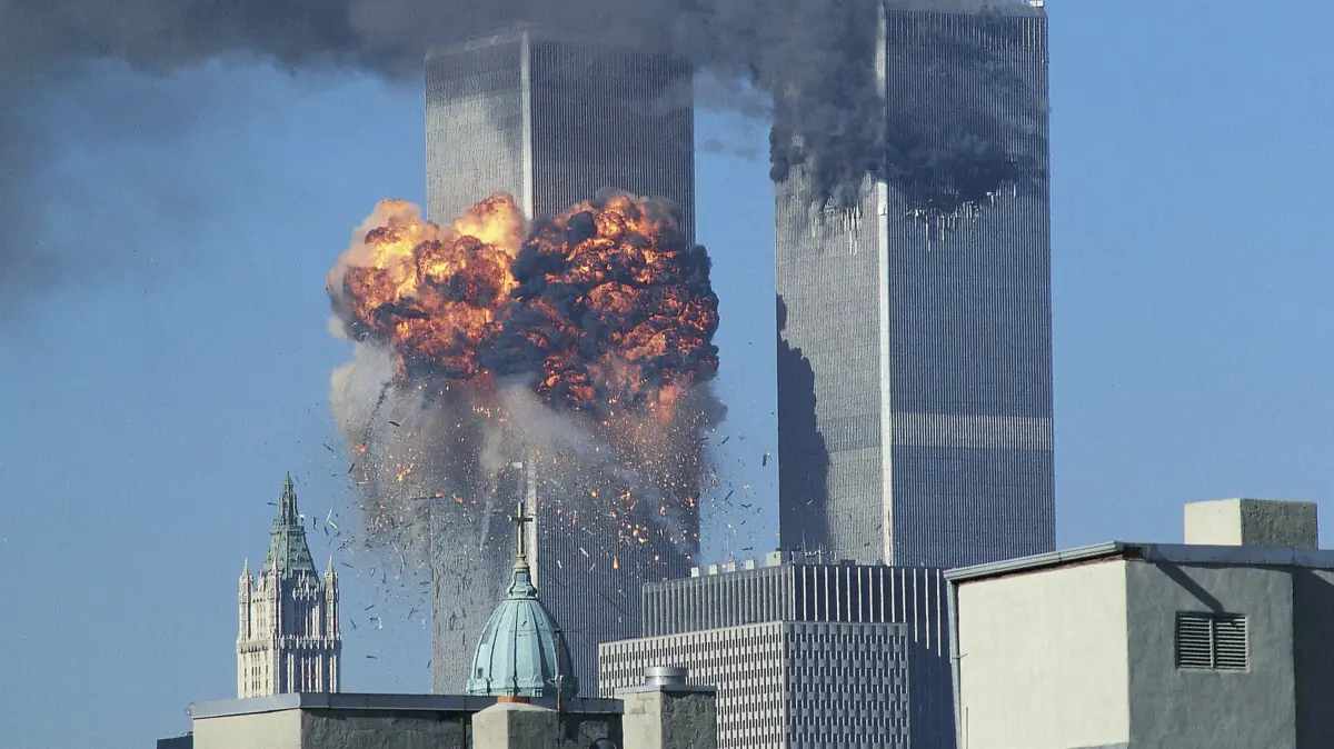 Amerika erinnert sich - 25 Jahre nach dem Terror von 9/11: Terroranschlag der Al Quaida am 11. September 2001 auf das World Trade Center in New York. Die Bilder haben sich eingebrannt: Flammen schlagen aus dem World Trade Center in New York , ein zweites Flugzeug fliegt in den Suedturm (Foto vom 11.09.2001), spaeter fallen die Zwillingstuermewie Kartenhaeuser in sich zusammen. Eine weitere Maschine stuerzt ins Pentagon, eine andere zerschellt auf einer Wiese bei Pittsburgh. Am 11. September 2001 verfolgte die Welt live im Fernsehen, wie der islamistische Terror die USA traf. Die Anschlaege mit rund 3.000 Toten waren eine Zaesur. Im Mittelpunkt des Gedenkens 25 Jahre spaeter stehen die Opfer sowie die Einsatzkraefte und Ersthelfer, die zu Hilfe eilten. Vermisst wird jedoch in den politisch gespaltenen USA den damals von vielen empfundenen gesellschaftlichen Zusammenhalt. (Siehe epd-Bericht vom 28.08.2026)
*** Local Caption *** 00260588