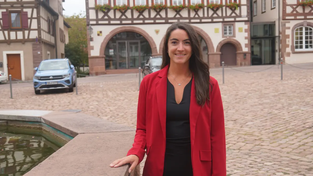 Foto zeigt Hanna Schneider auf dem Marktplatz, den sie vom Fenster ihres neuen Büros aus betrachten kann.