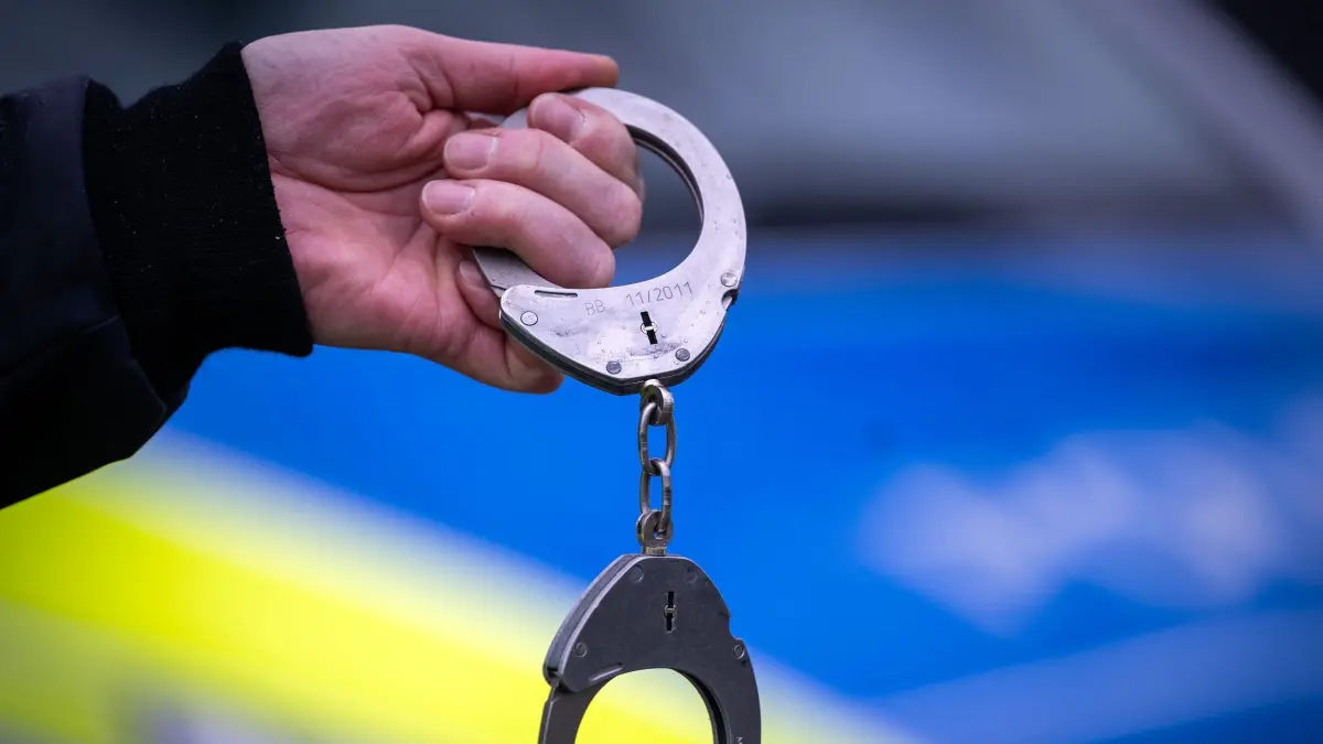 Handschellen Symbolbild: ARCHIV - 22.03.2024, Brandenburg, Trebbin: Ein Polizist hält während einer Verkehrskontrolle an der Berliner Straße ein Paar Handschellen. (zu dpa: «Flucht nach Einbruch: Polizei nimmt Verdächtigen fest») Foto: Soeren Stache/dpa +++ dpa-Bildfunk +++