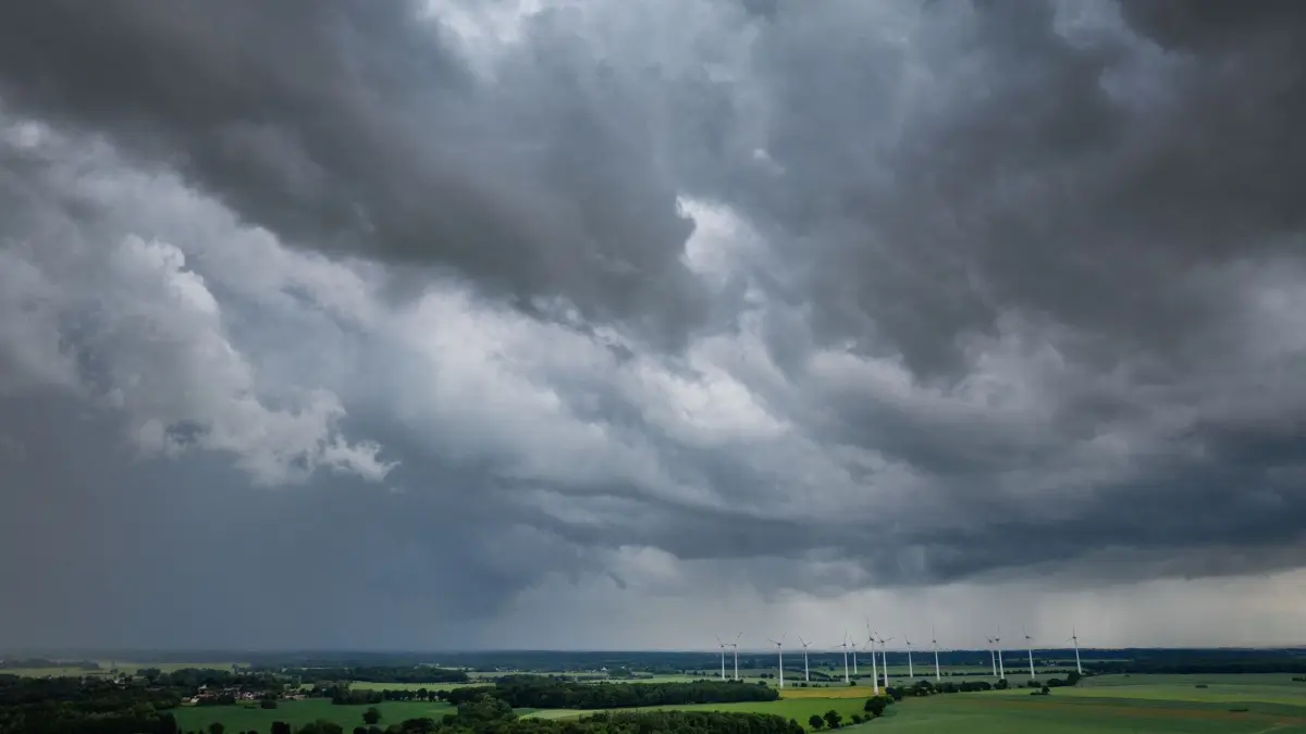 Gewitter über Norddeutschland: ARCHIV - 04.06.2026, Mecklenburg-Vorpommern, Neuendorf: Dunkle Gewitterwolken ziehen über einen Windpark (Luftaufnahme mit Drohne). (zu dpa: «Kein Sturm wie am Freitag - Wie sich der Wind weiter verhält») Foto: Jens Büttner/dpa +++ dpa-Bildfunk +++