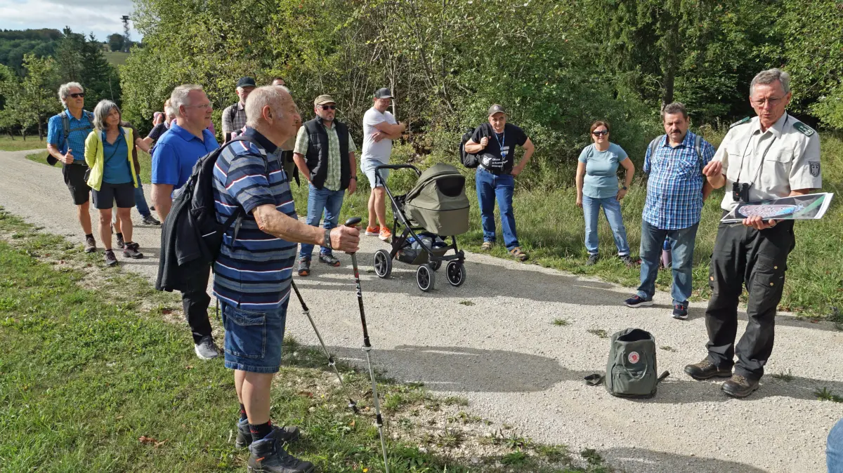 Marco Reeck, der Leiter des Bundesforstbetriebs Heuberg, führte die Wandergruppe über den ehemaligen Truppenübungsplatz. Links im Hintergrund ist der Beobachtungsturm Heroldstatt zu sehen. Bei der Wanderung geht man auf der sonst für die Öffentlichkeit gesperrten Panzerringstraße.